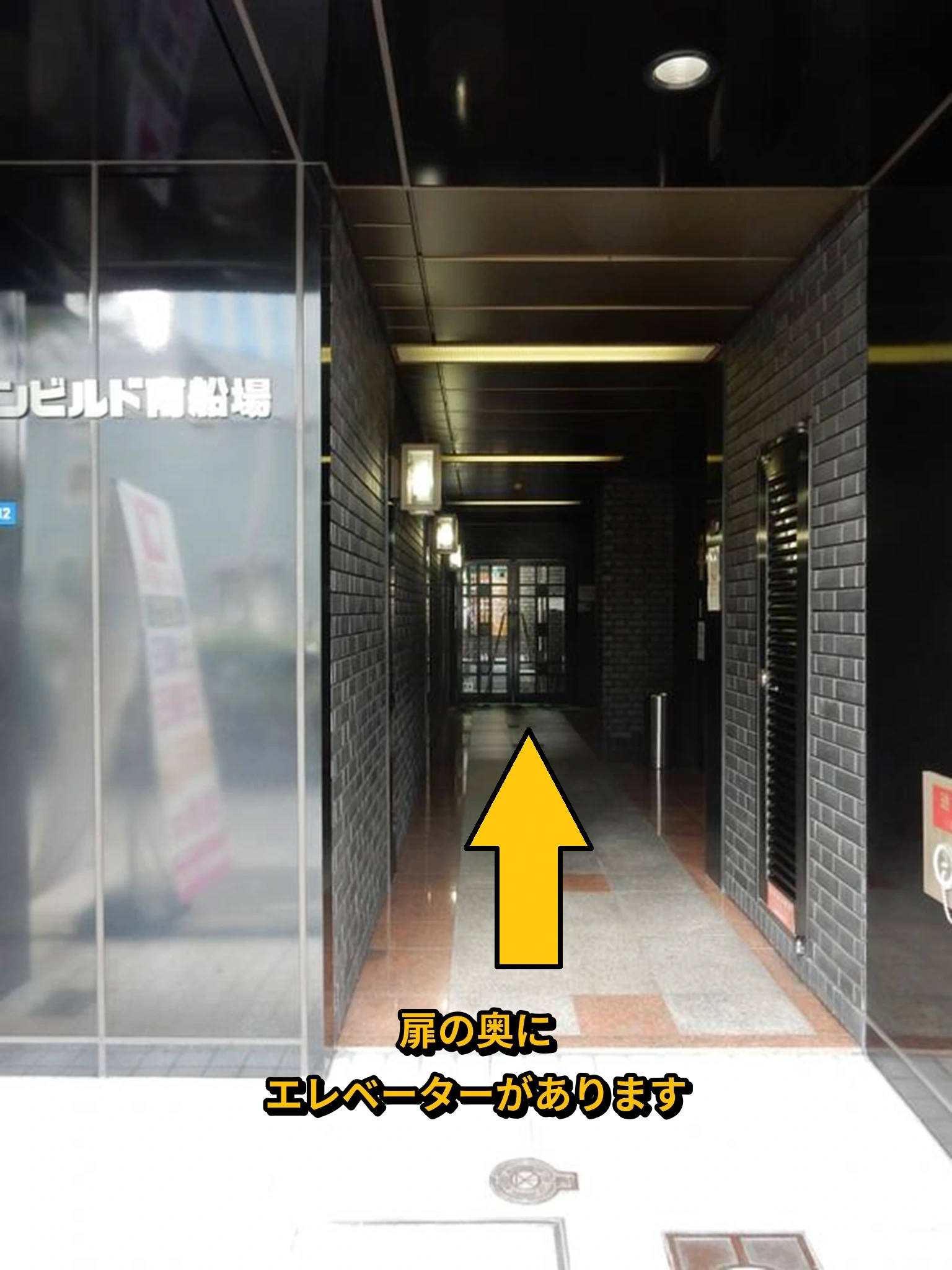 ビル入口から奥のエレベーターへ進む案内